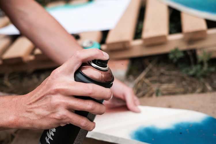 Cropped hand of woman using spray paint