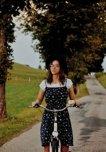 Portrait of a smiling young woman standing on road