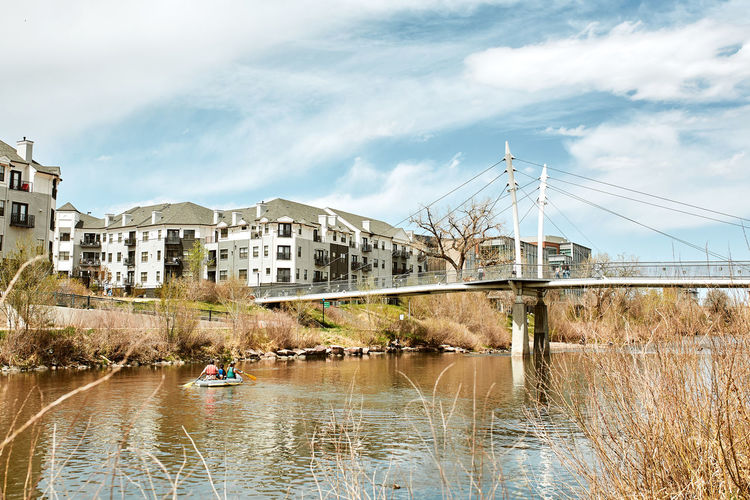 South platte river bridge by apartments and office buildings in commons park, denver, colorado