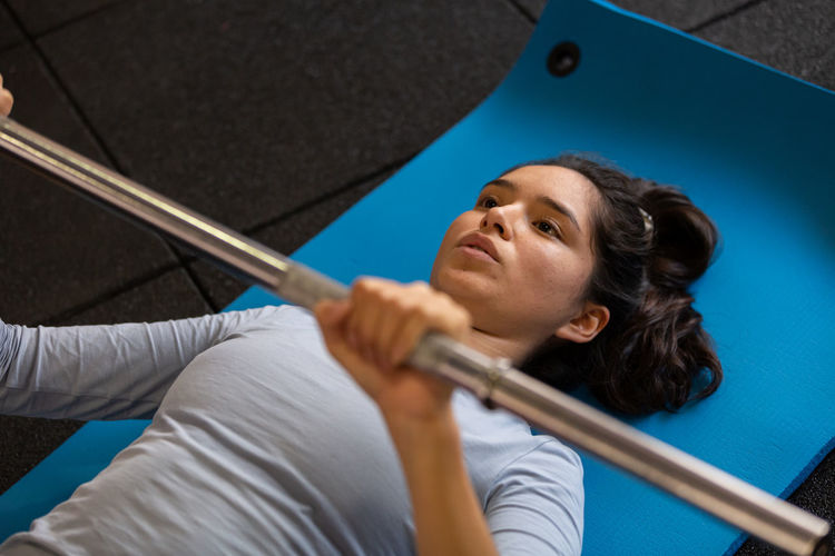 Low angle view of young woman standing against wall