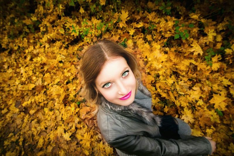 High angle portrait of woman standing on field during autumn