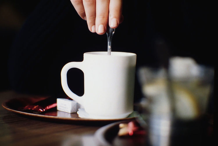 Close-up of hand stirring coffee