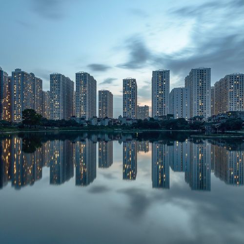 Reflection of buildings in river against sky
