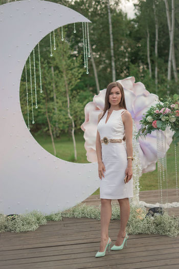 Portrait of smiling bride standing against decorations during wedding ceremony