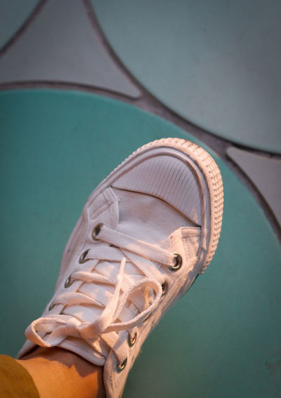 Low section of person wearing white shoe
