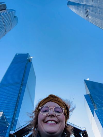 Portrait of smiling woman against buildings in city 