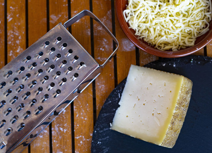 Cheese grater next to parmesan cheese.