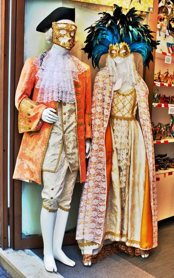 Costumes in mannequins displayed at store for sale