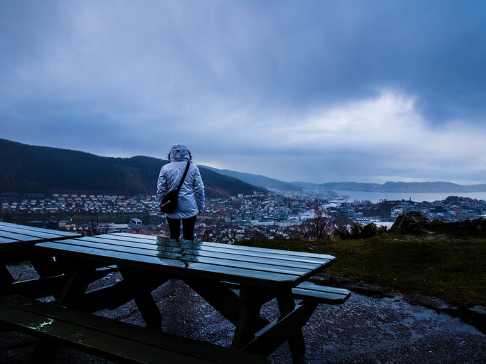 Person standing on bench against mountains