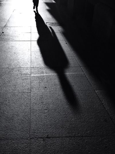 Shadow of person walking on footpath