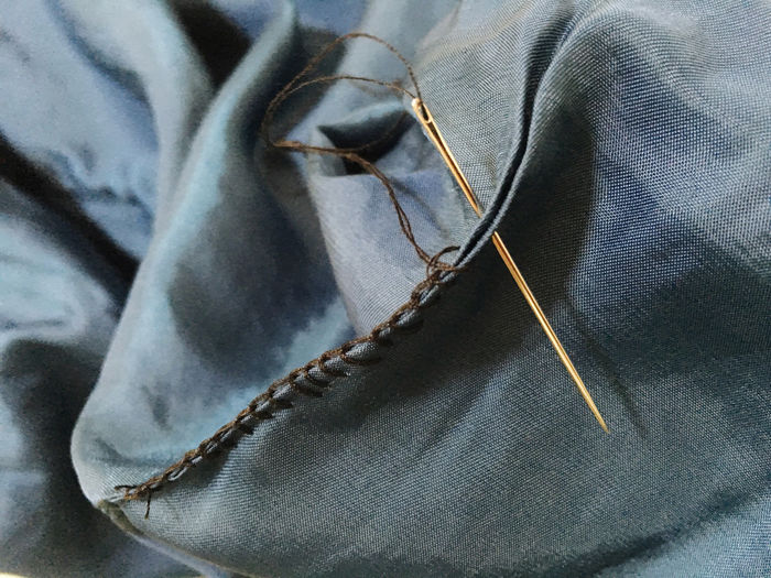 Close-up of needle sewing textile