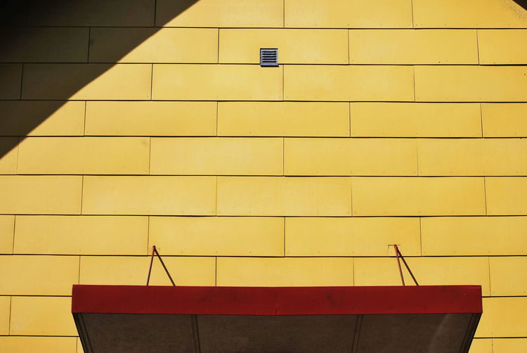 Low angle view of yellow wall against building