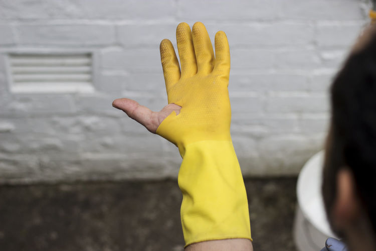 Close-up of woman hand holding yellow wall