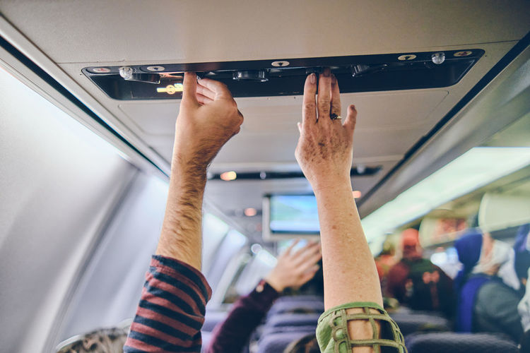 Hand up to adjust console panel aircraft, selective focus. travel concept
