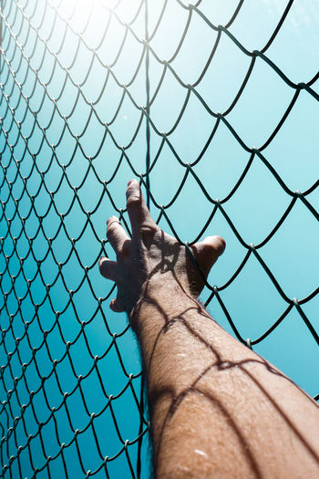 Hand grabbing a metallic fence