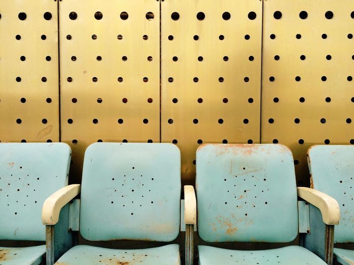 Empty chairs against patterned wall