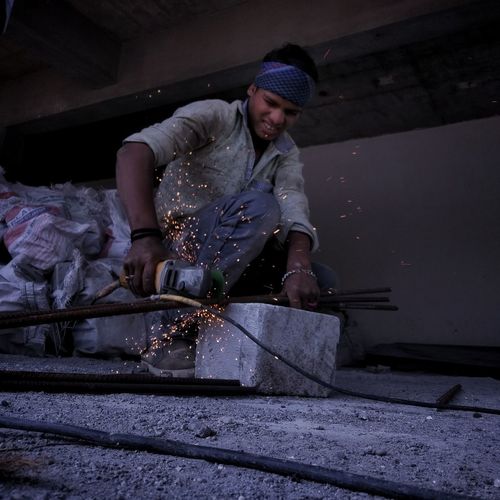 Worker drilling metal at workshop
