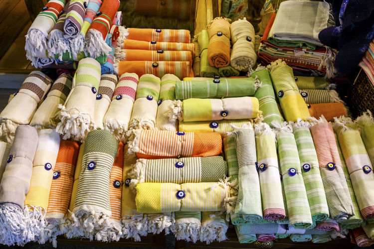 High angle view of rolled up towels tied with evil eye beads at market for sale