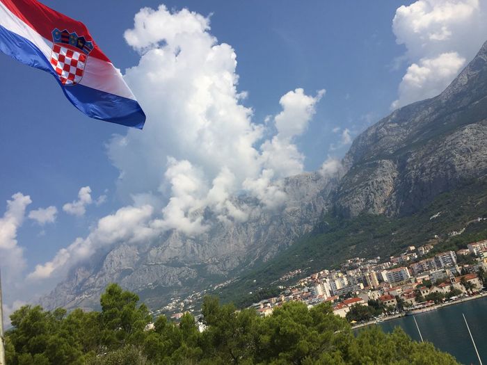 Low angle view of croatian flag and mountain against sky
