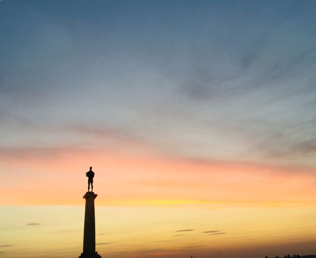 Low angle view of silhouette statue against sky during sunset