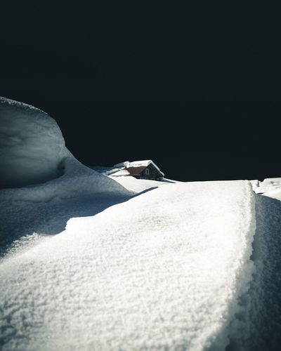 Snow covered land against clear sky