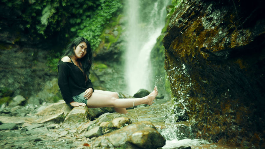 Young woman looking at waterfall