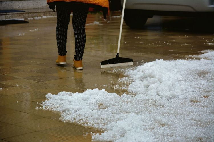 Woman clearing hail with mop