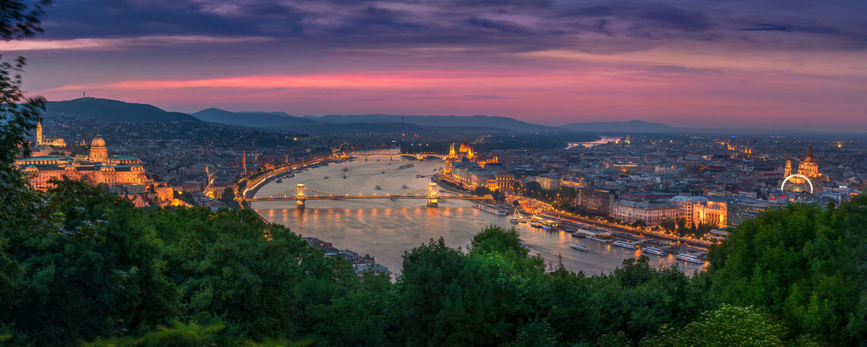 Aerial view of illuminated cityscape during sunset