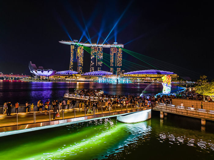 Illuminated bridge over river at night