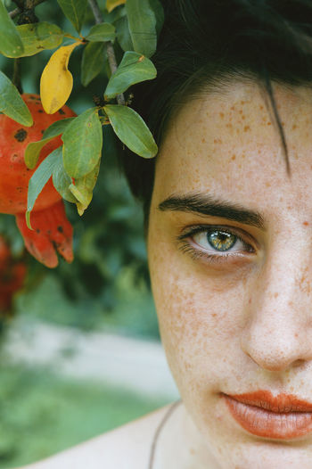 Close-up portrait of teenage girl with leaves