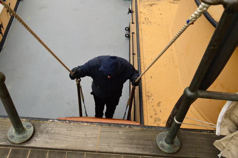 Rear view of man working on railing