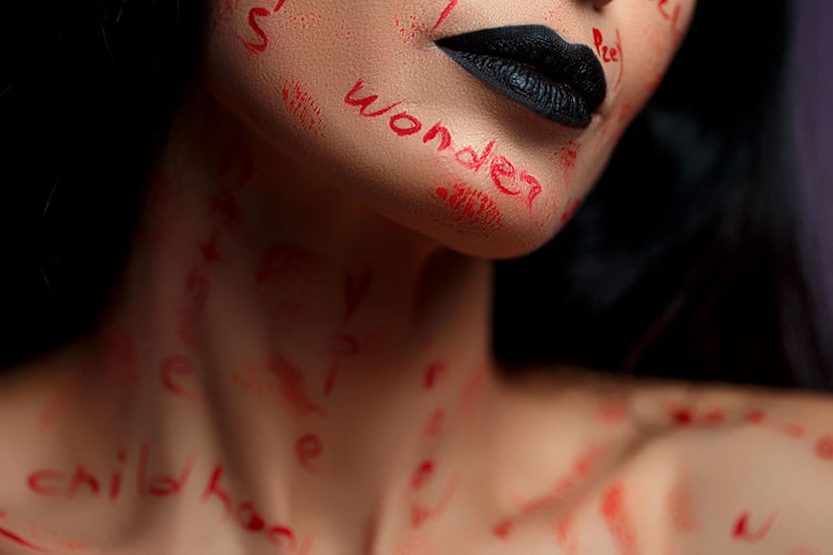 Midsection of woman with text on face
