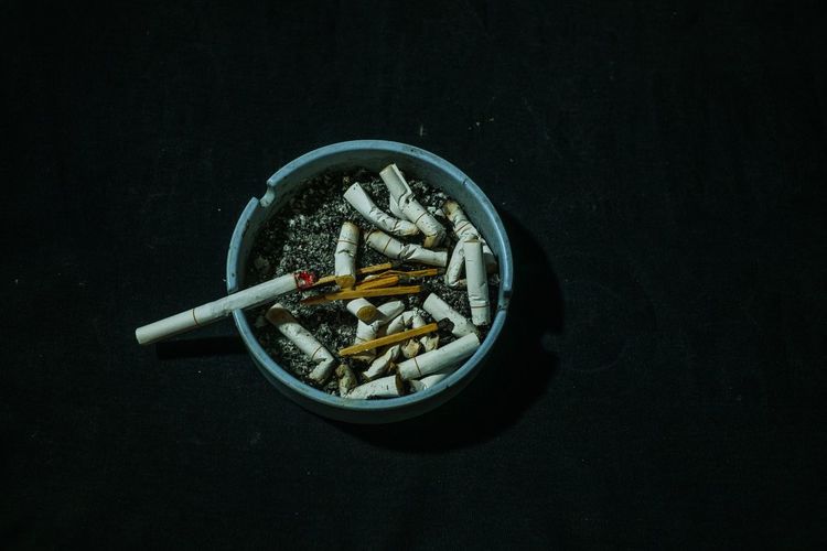 Close-up of cigarette on table against black background