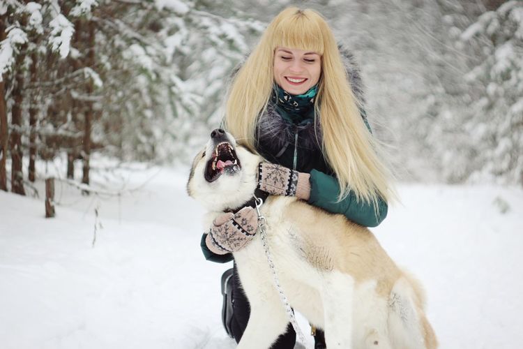 Young woman with dog on snow