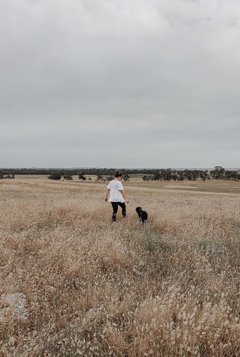Woman walking with dog on field