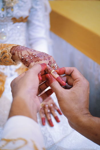 Close-up of couple holding hands during wedding