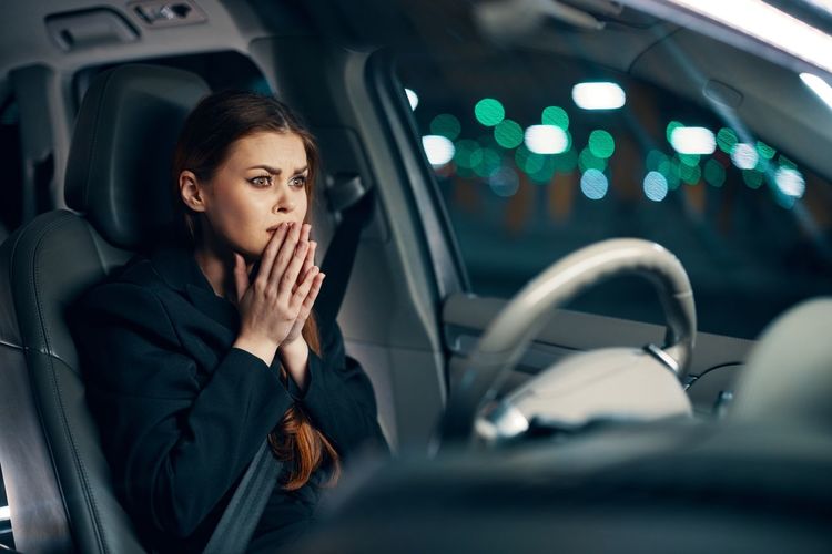 Young woman using mobile phone while sitting in car