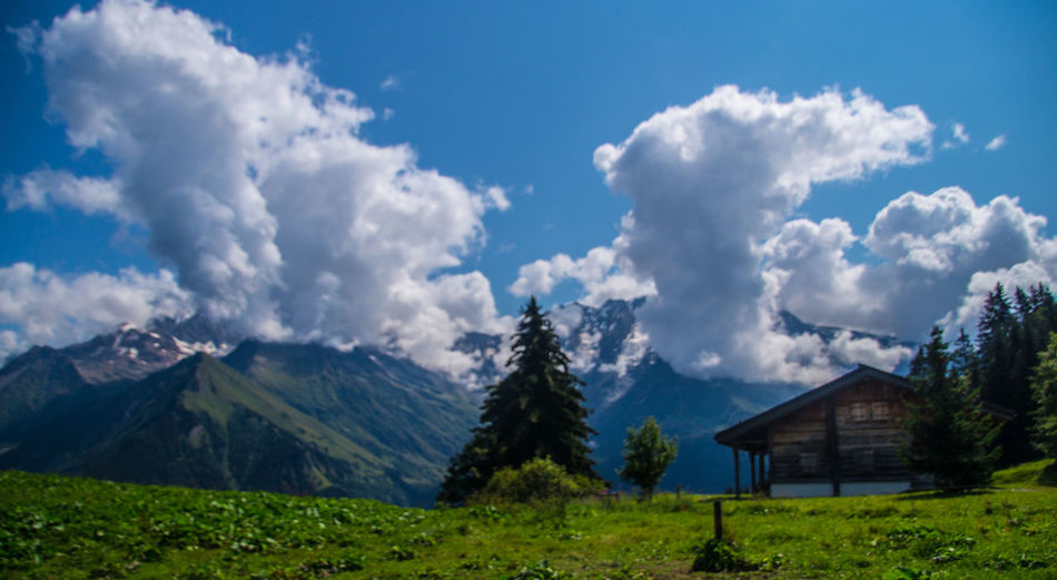 Scenic view of house and mountains against sky