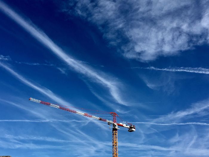 Low angle view of crane against blue sky