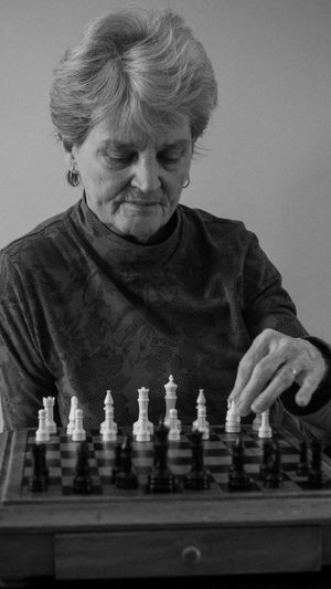 Low angle view of woman playing chess in background