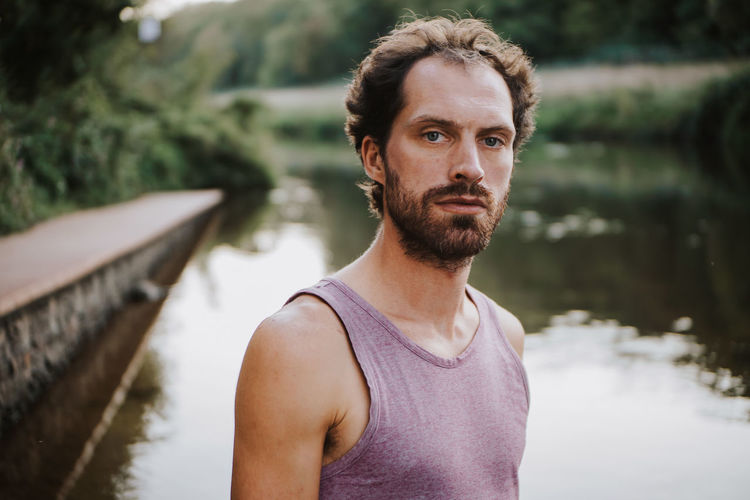 Portrait of man standing against lake