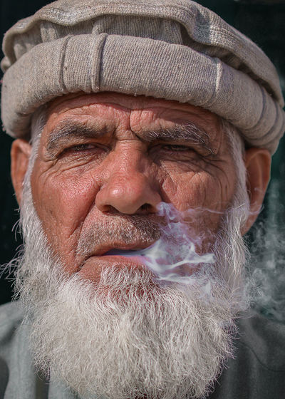 Close-up portrait of man exhaling smoke
