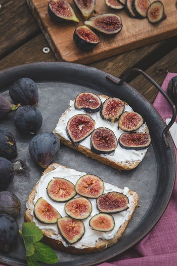 Top view of soft ricotta sandwich with ripe figs served on a tray.