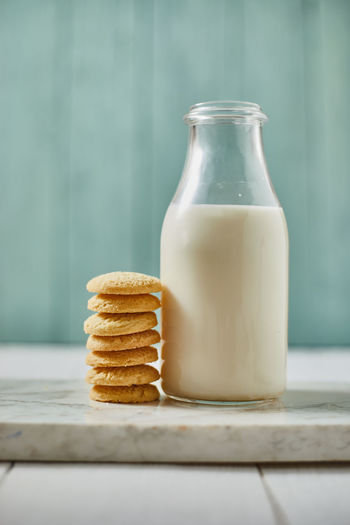 Cookies by milk in bottle on table