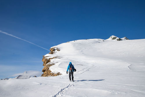 Person on snowcapped mountain against sky