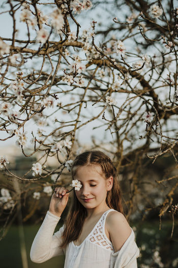 Portrait of girl with plants against trees