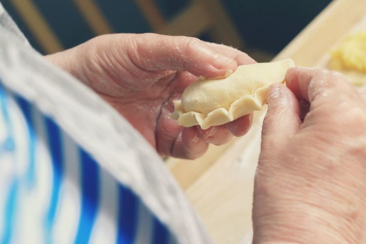 Cropped image of person making dumpling