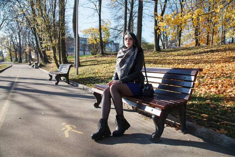 Woman sitting on bench in park