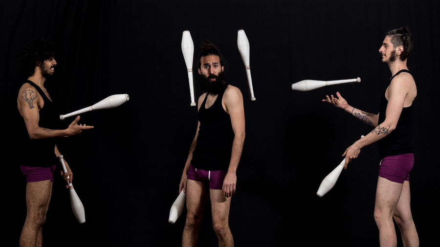 Men juggling while standing at stage
