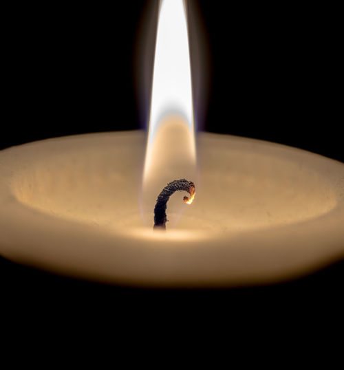 Close-up of candle over black background